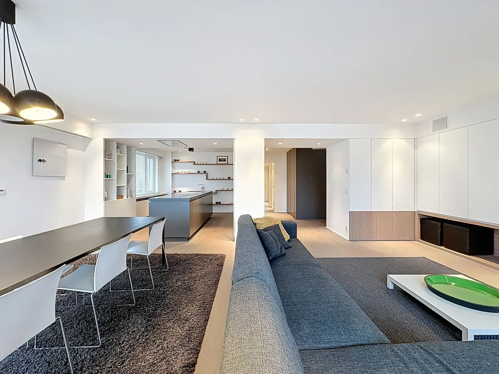 Doorkijk van de eetruimte naar de open keuken van het appartement